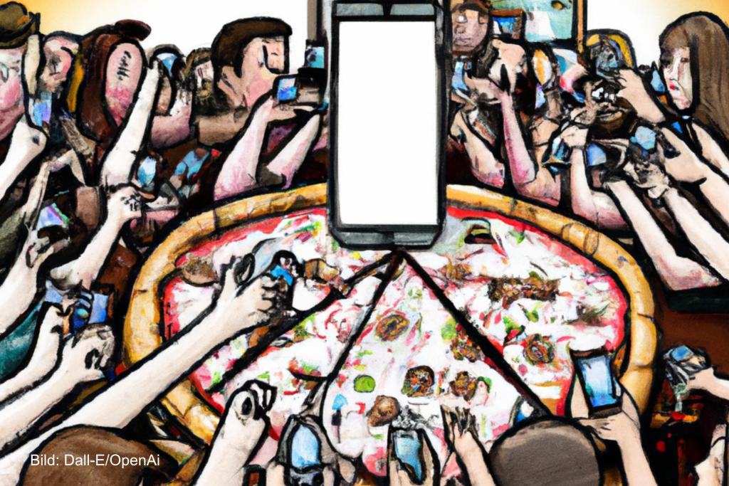 Menschen machen Fotos von einer Pizza und beten ein Handy an. Symbolbild für die Influencerinnen Fodor und Hingsammer von Babetown.