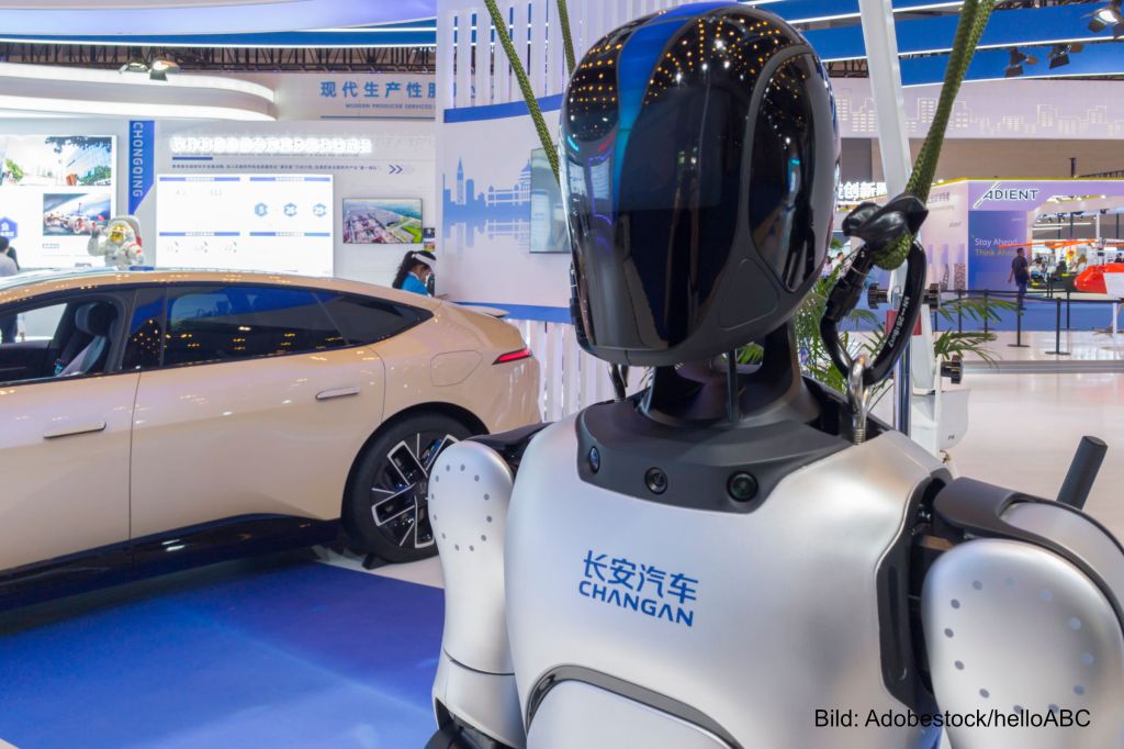 Ein Humanoider Roboter steht in China neben einem Elektroauto. Automobilzulieferer müssen diversifizieren, um zu überleben.